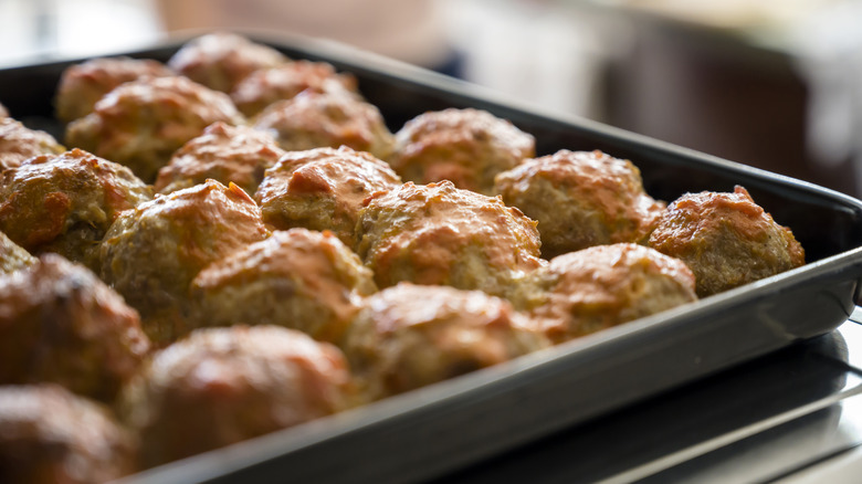 close up of meatballs on baking tray