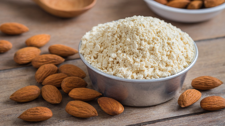 Almond flour in bowl and whole almonds