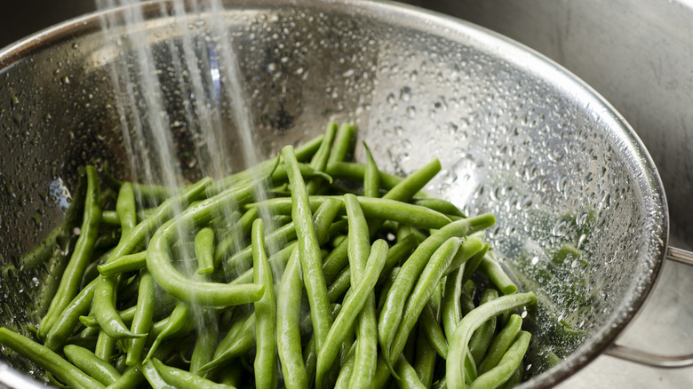 Washing fresh green beans in bowl