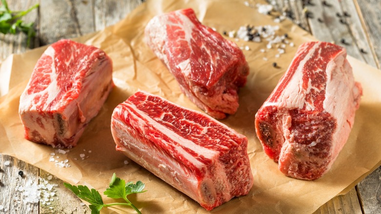 Four raw bone-in beef short ribs
