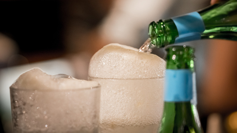 tonic water pouring into glasses