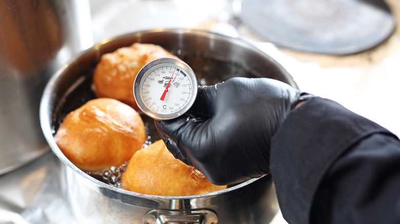 Thermometer in oil frying doughnuts