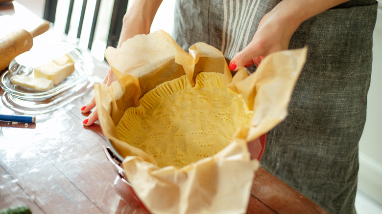 Woman's hands holding unbaked pie crust