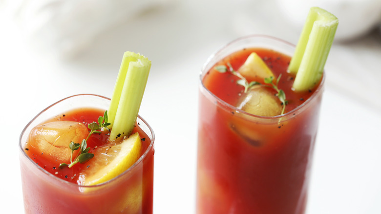 A pair of bloody marys with a celery garnish