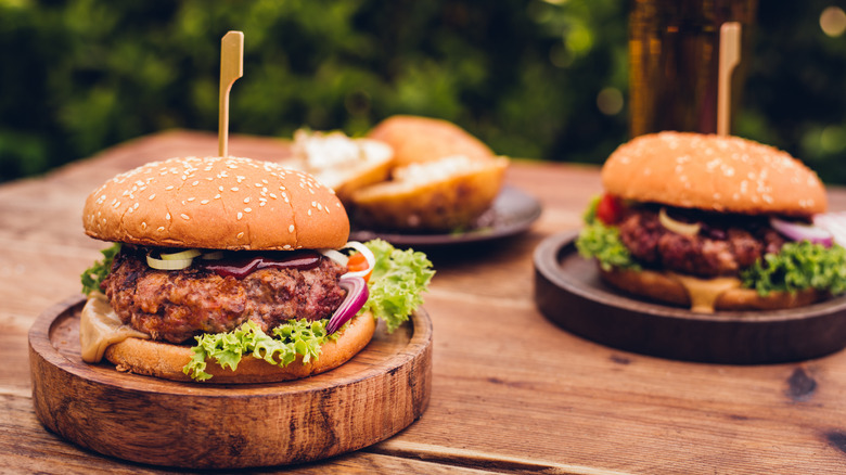 assembled burgers on wooden plates