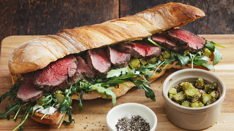 steak sandwich with pickles and arugula