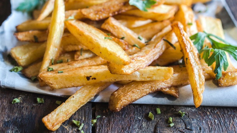 Garnished French fries on napkin