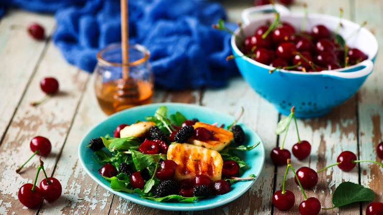 Halloumi on salad with cherries and honey