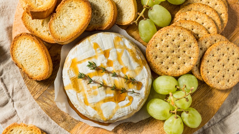 Baked brie surrounded by crackers and grapes