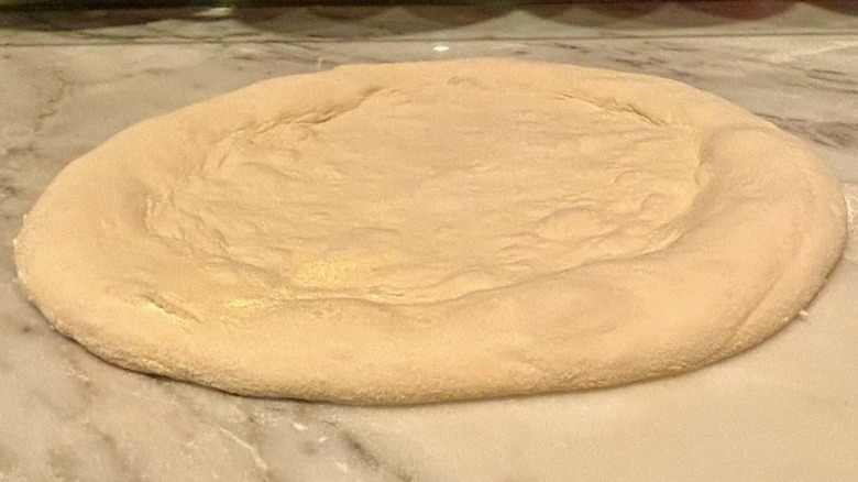 Uncooked round of pizza dough