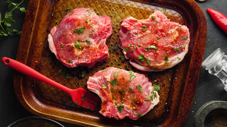 Marinated pork chops on baking sheet