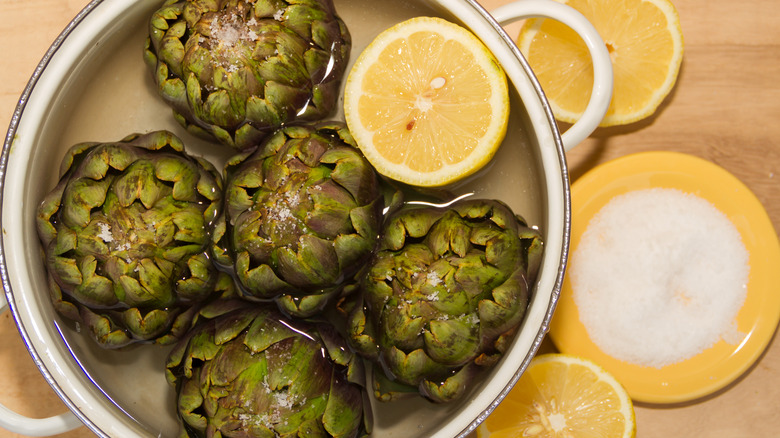 Artichokes with lemon in pot