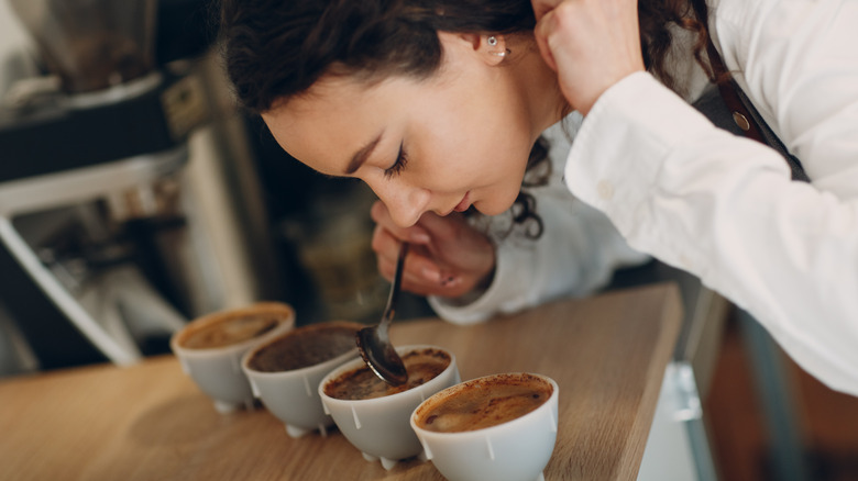 Person smelling row of coffee