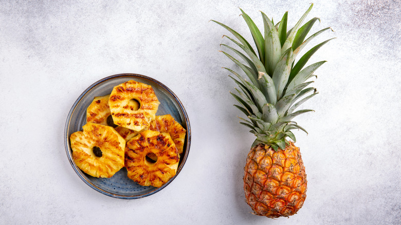 Whole pineapple next to plate