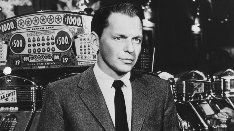 Frank Sinatra poses in front of slot machine