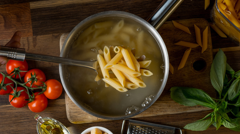 scooping pasta out of water