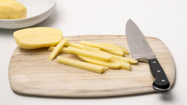 slicing fries on chopping board