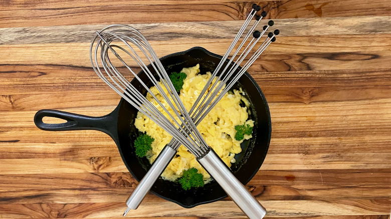 Whisks crossed over pan of eggs