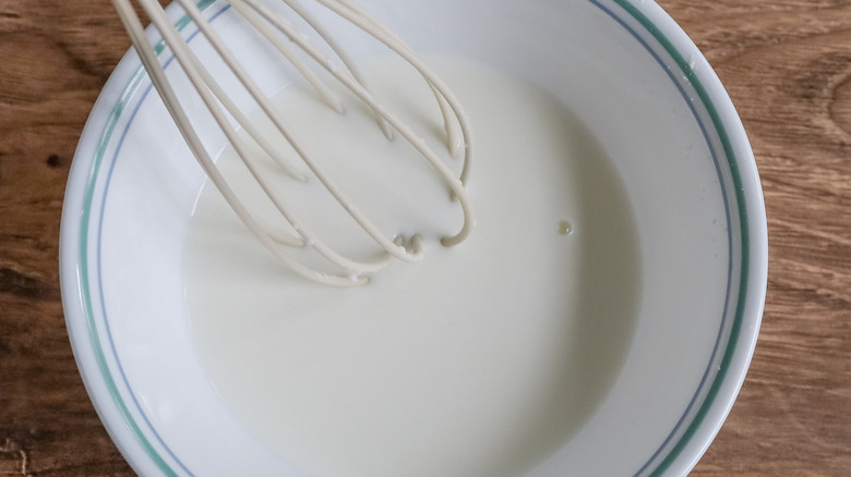 white liquid and whisk in bowl