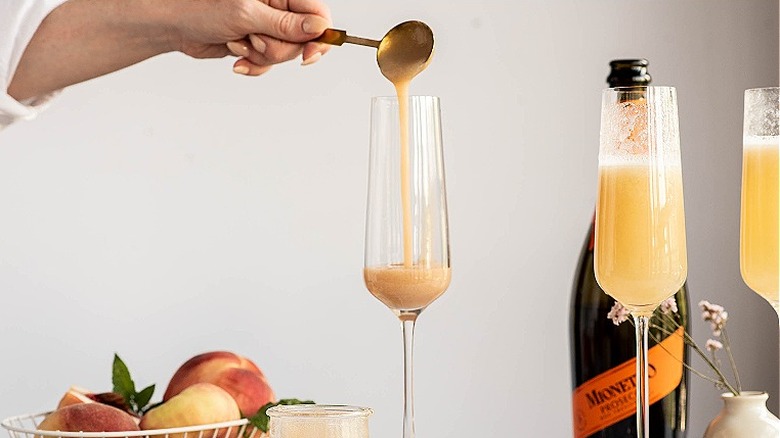 spooning peach puree into cocktail