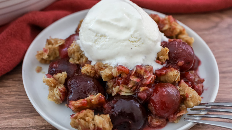 a plate of cherry crisp with ice cream on a table