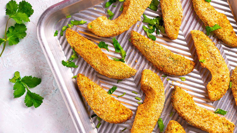 breaded avocados on a baking tray