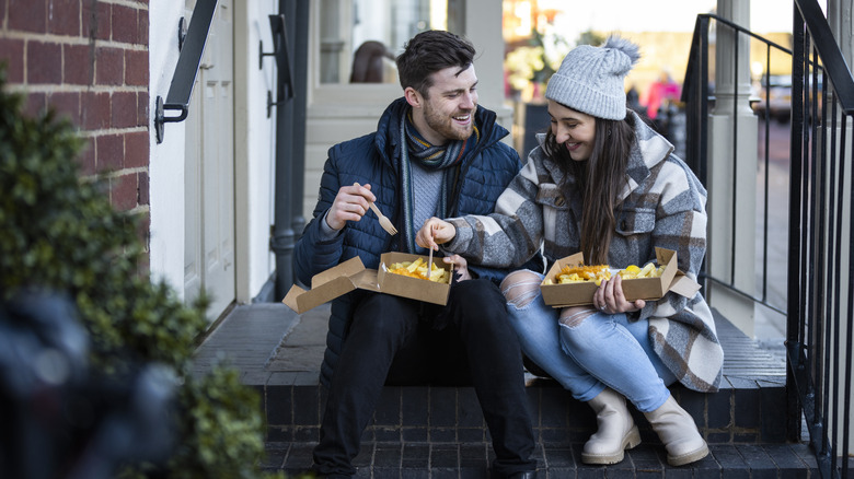 Two foodies enjoying takeaway fish and chips