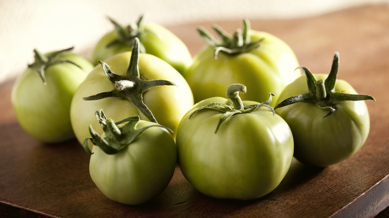 Green tomatoes on wooden table