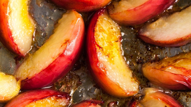 Close-up of fried peach slices in a pan caramelizing