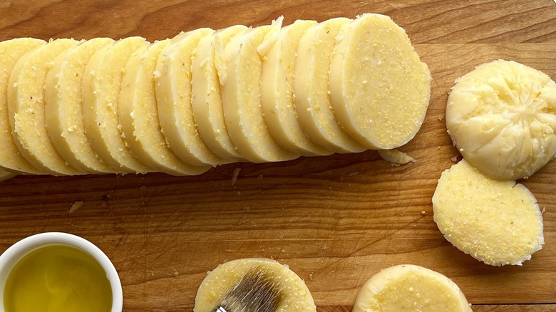 sliced polenta rounds on a wooden cutting board