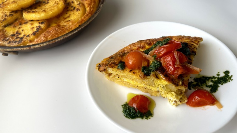 a slice of fried polenta frittata topped with tomato sauce and pesto