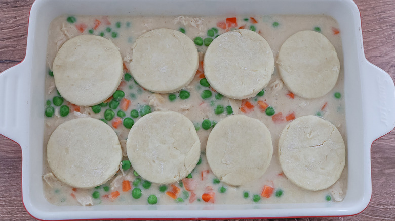 raw biscuits on vegetables and gravy