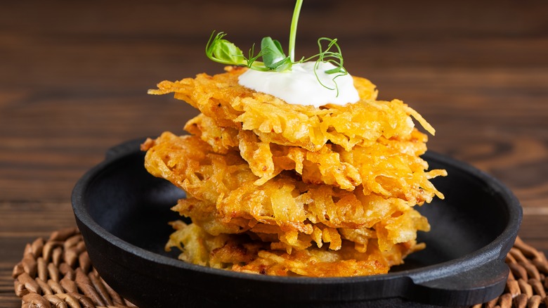 potato pancakes stacked over dark plate