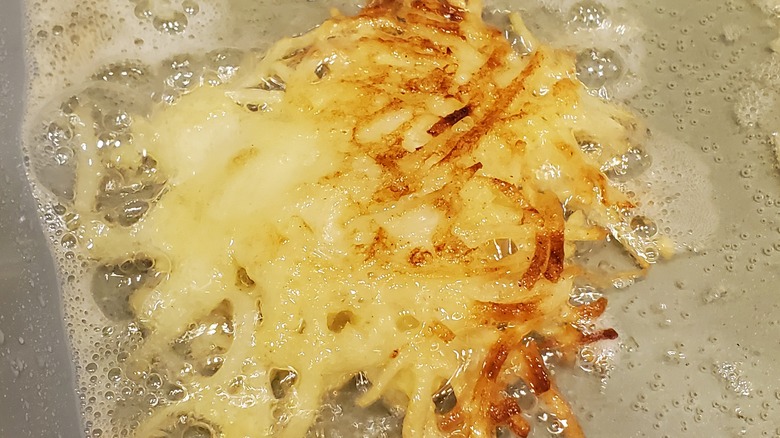 closeup of a potato pancake frying