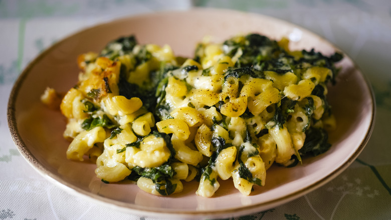 macaroni and hceese and spinach on a pink plate