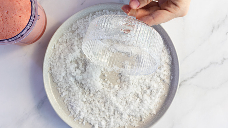 Rolling margarita glass in salt