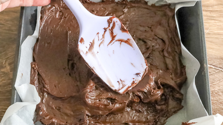 spreading brownie batter in pan