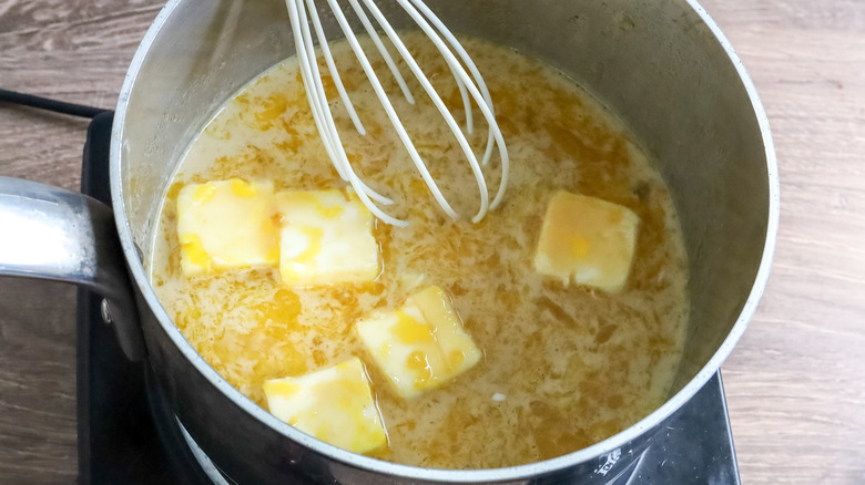 whisking butter mixture in saucepan