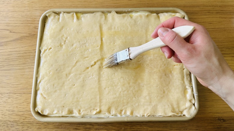 brushing butter on cake sheet