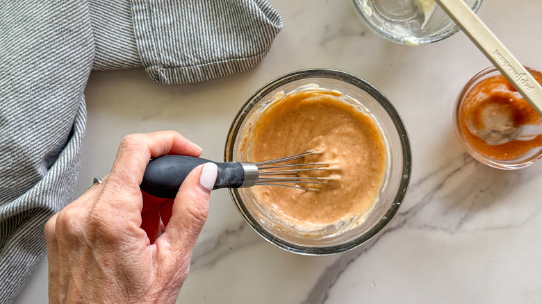 hand stirring sauce with whisk