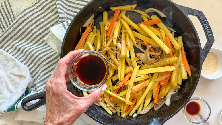 hand adding soy sauce