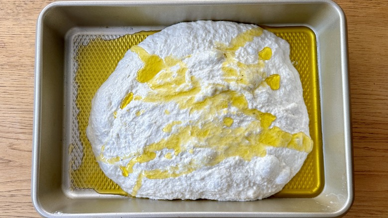 Oiled focaccia dough in pan