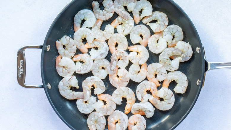 uncooked shrimp in pan