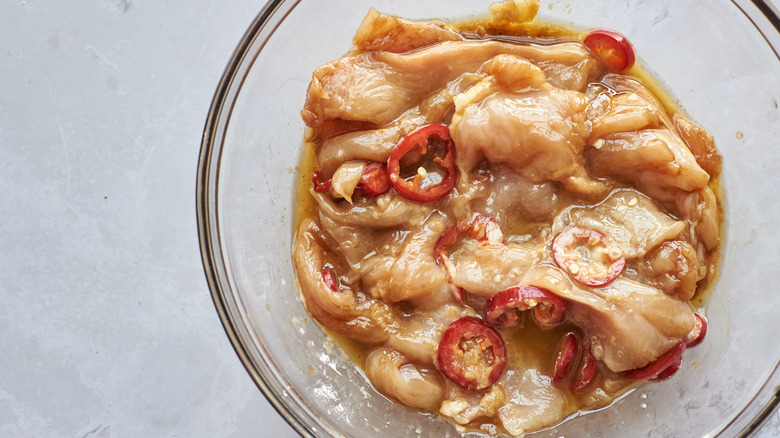 chicken marinating in a bowl