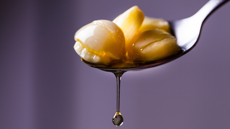 spooning garlic out of olive oil