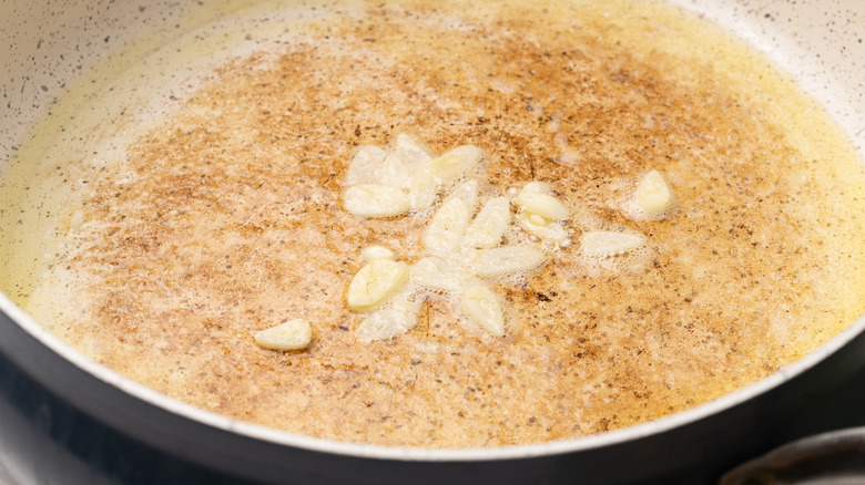 Sliced garlic frying in oil