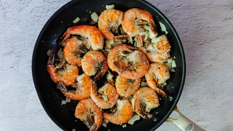 Seared shrimp in a pan with aromatics