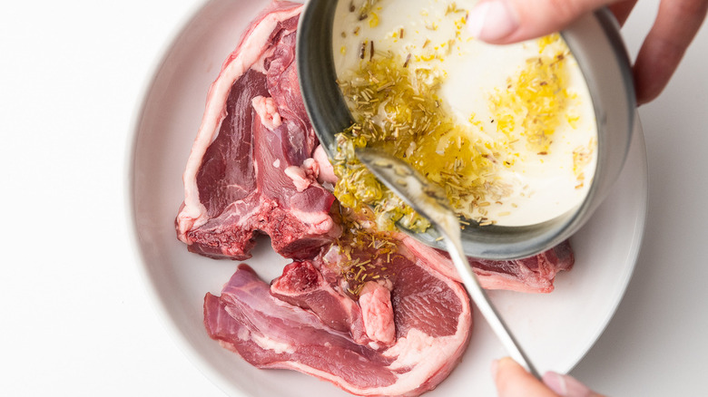 pouring marinade onto raw lamb