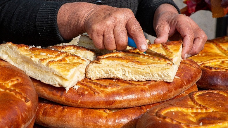 Woman cuts slices of gata