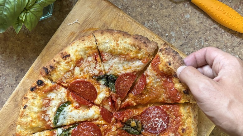 hand holding slice of pizza